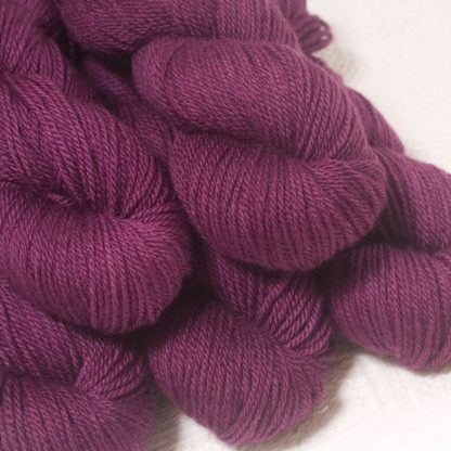 Tyrian Purple - Dark reddish purple Bluefaced Leicester worsted weight yarn hand-dyed by Triskelion Yarns