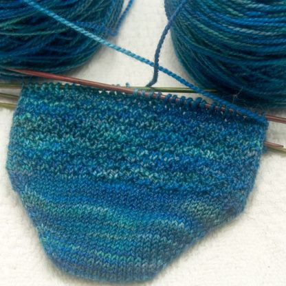 A Tale From The Riverbank - variegated blues greens and teals with flashes of silvery grey GOTS standard organic machine-washable Merino 4-ply / fingering weight yarn. Hand-dyed by Triskelion Yarn
